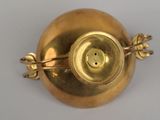 a gold vase that is sitting on a table