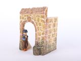 a figurine of a man and a woman in front of a gate