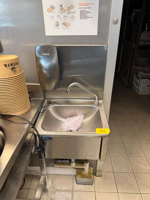 un évier de cuisine avec beaucoup de vaisselle sur le plan de travail