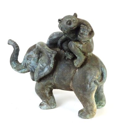 une statue représentant un homme chevauchant un éléphant sur le dos duquel se trouve un chat