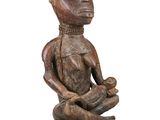 an image of a statue of a person sitting on a wooden base