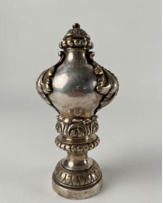 a silver vase that is sitting on a table