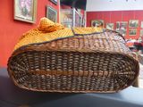 a wicker basket with a yellow blanket on top of it