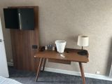 a small desk with a lamp and a television on it