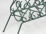 a green metal magazine rack that is on a white surface