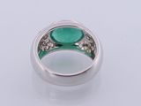 a close up of a ring with a green stone in it