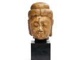 une image représentant une tête sculptée posée sur un socle noir