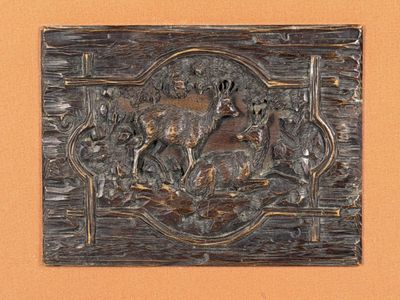 a metal plaque with a picture of a deer on it