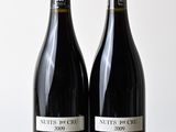 deux bouteilles de vin posées l'une à côté de l'autre sur une table en bois