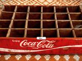 une vieille caisse en bois de Coca-Cola posée sur une nappe à motifs