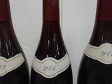 three bottles of wine are lined up on a table