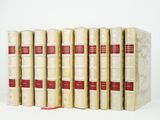 six books in a row on a white surface with a red ribbon