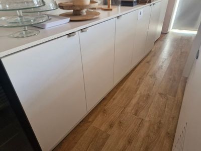 an image of a kitchen with white cabinets and wood floors