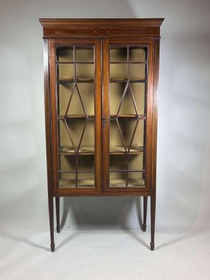 une vitrine ancienne avec des portes vitrées et un socle en bois
