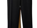 Le mannequin porte un pantalon noir et une chemise blanche.