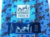 a blue tie with horses on it on a white table