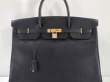 un sac à main en cuir noir orné d'un fermoir doré