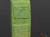 chinese jade snuff bottle with green glaze on a black surface