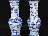 pair of blue and white vases on a black background