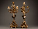 pair of antique bronze candelabs with a picture of a woman and a man