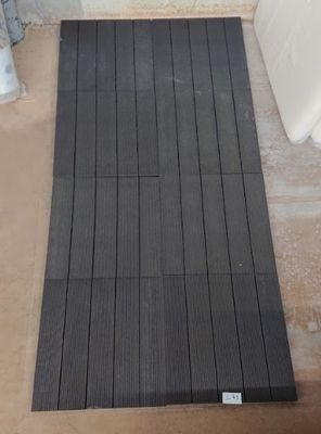 un tapis noir posé par terre à côté des toilettes