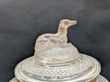a glass bowl with a dog on top of it