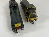 two trains that are sitting side by side on a white surface