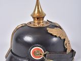 an old helmet with a gold decoration on the top of it