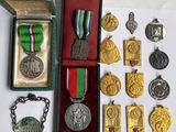 de nombreuses médailles, rangées dans une boîte posée sur une table