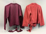 deux pulls rouges suspendus à un portant à linge muni de crochets