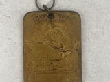 an old brass plate with a bird on it on a white surface