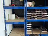 a blue shelving with shelves and a stool in it