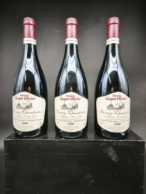trois bouteilles de vin rouge sont posées sur une boîte noire