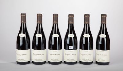 six bottles of wine lined up in a row on a table
