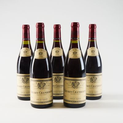 quatre bouteilles de vin sont alignées sur une surface blanche