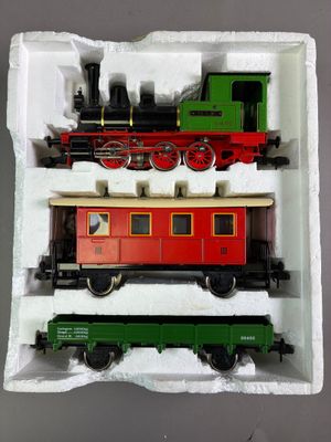 trois petits trains miniatures posés dans une boîte sur une table
