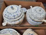 a box of blue and white plates and bowls in it