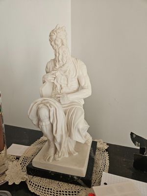 a statue of a man sitting on top of a table