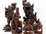 un ensemble de quatre figurines en bois sculpté représentant des personnages et des animaux