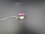 un gros plan d'une bague posée sur une table, à laquelle est attachée une ficelle