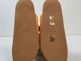 the back of a pair of yellow shoes with a white background