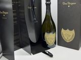 une bouteille de champagne posée à côté d'une boîte noire