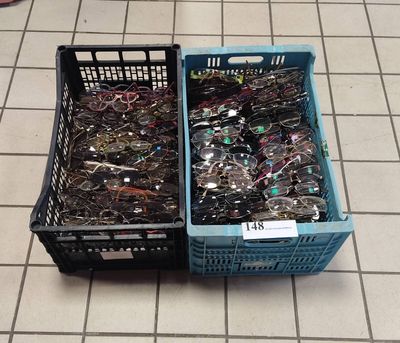de nombreuses paires de lunettes posées dans un panier posé par terre