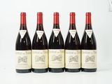 six bouteilles de vin rouge sont alignées sur une surface blanche