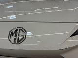 the front end of a white car with a logo on it