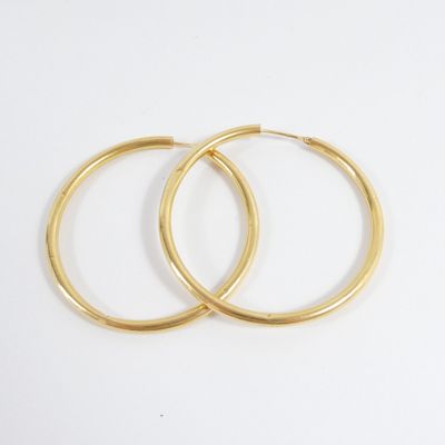 two pairs of gold hoop earrings on a white background