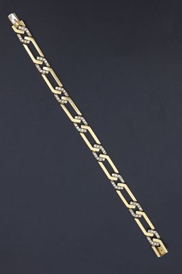 gros plan d'un bracelet en chaîne en or sur fond noir