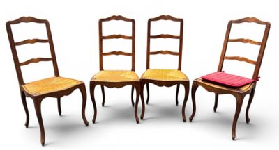 trois chaises en bois avec des coussins rouges sont disposées côte à côte sur une surface blanche