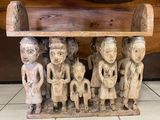 un banc en bois sur lequel est représenté un groupe de personnages sculptés