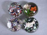 four glass marbles with different designs on them sitting on a table